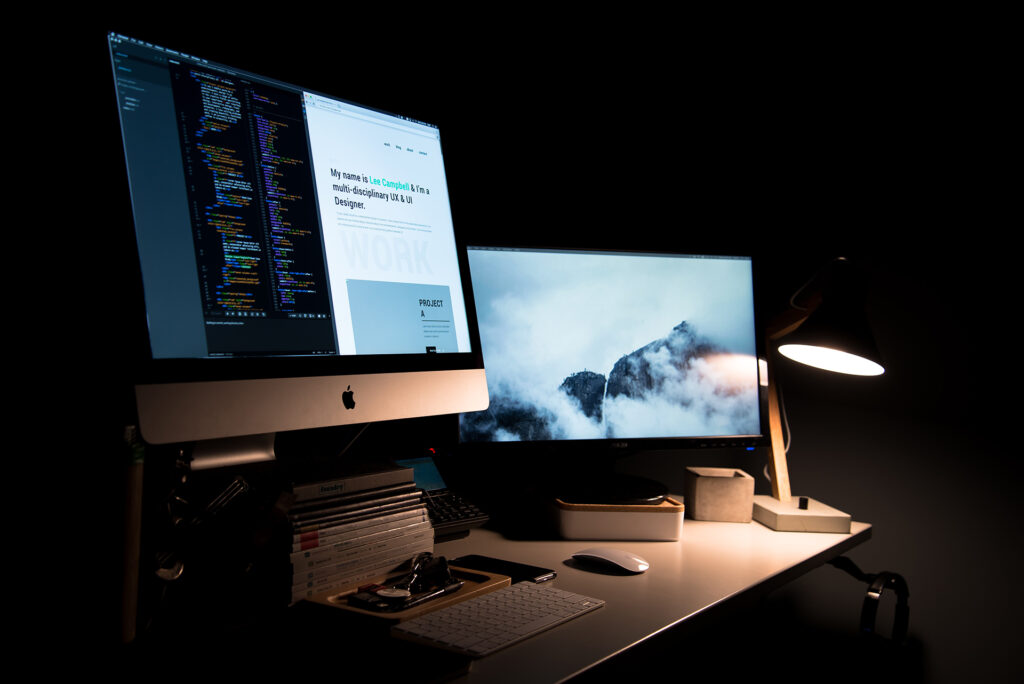 A computer with 2 monitors showing website development